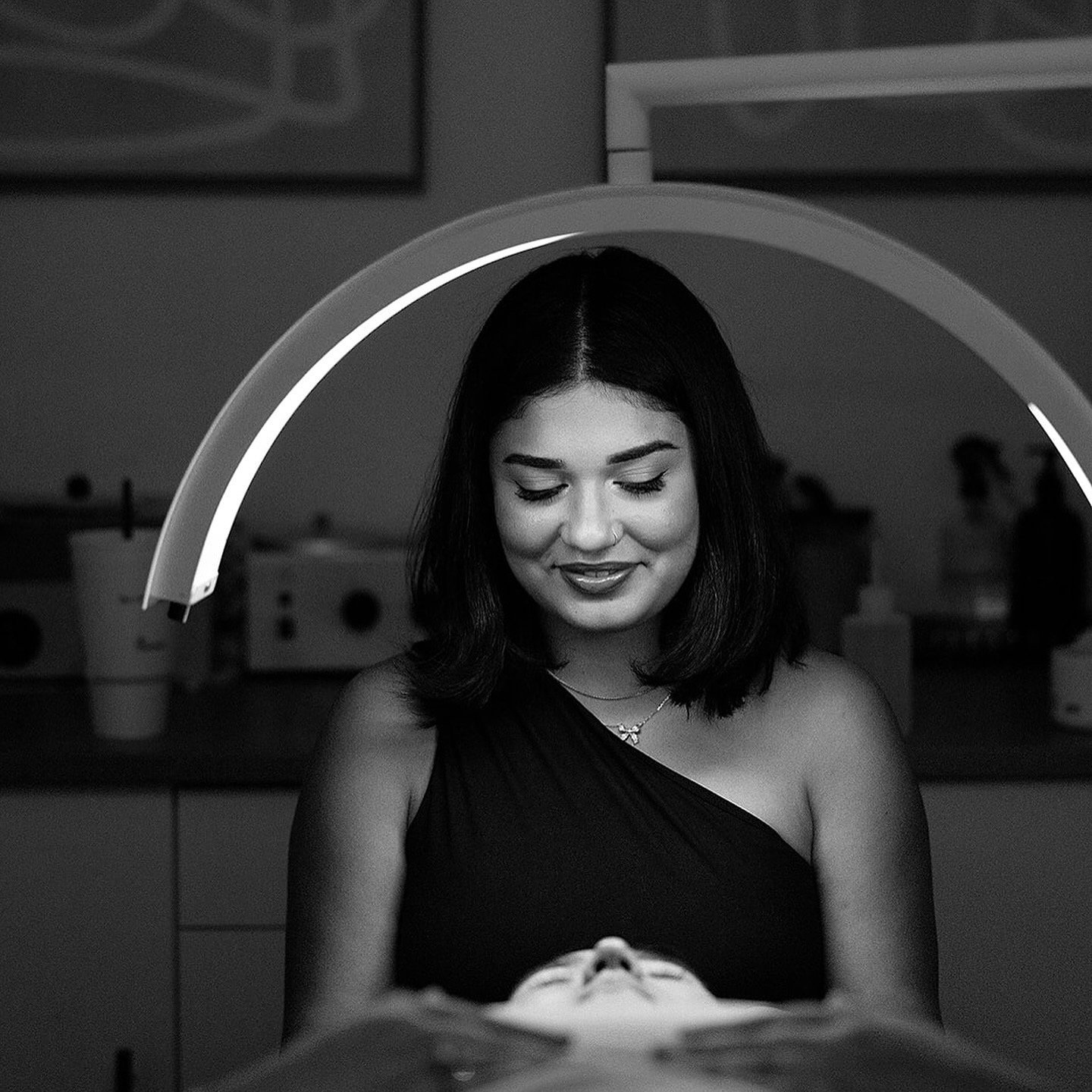 Maria performing a facial under treatment light